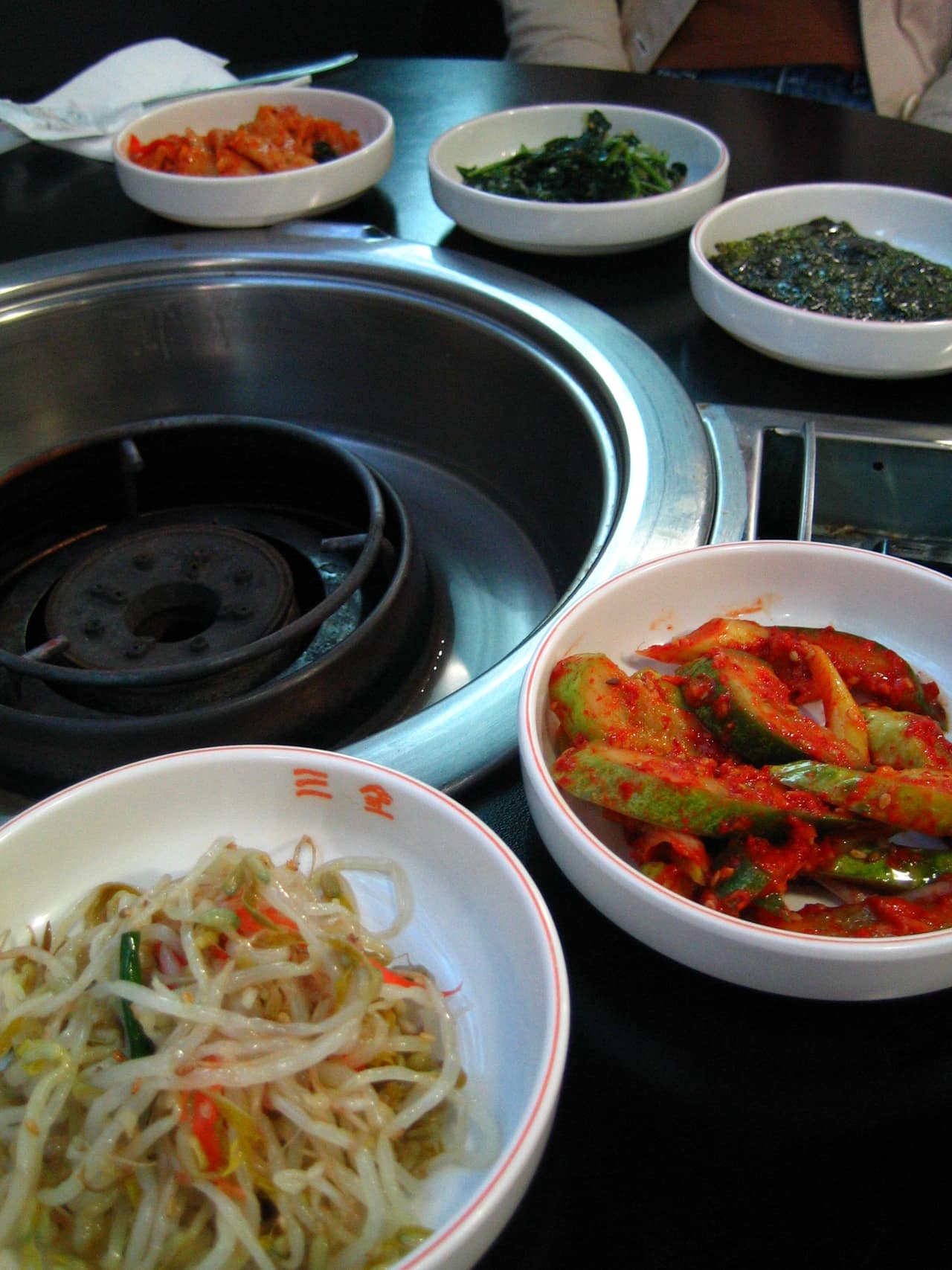 An assortment of small Korean side dishes in white bowls