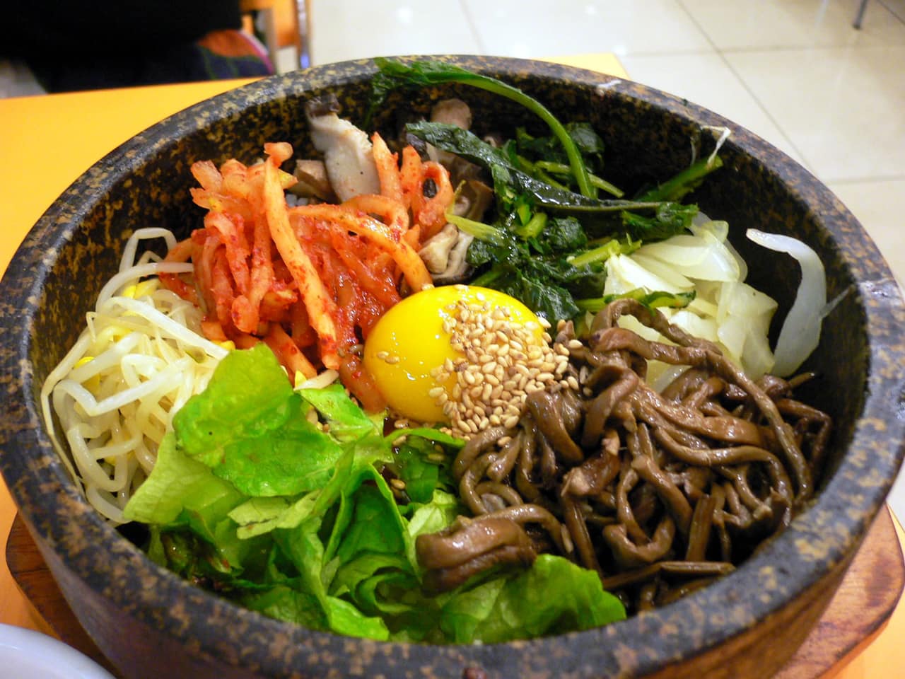 Dolsot bibimbap in a hot stone bowl topped with vegetables and egg