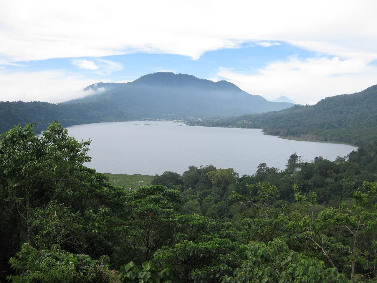 Still water and forested crater walls at Lake Tamblingan in north Bali