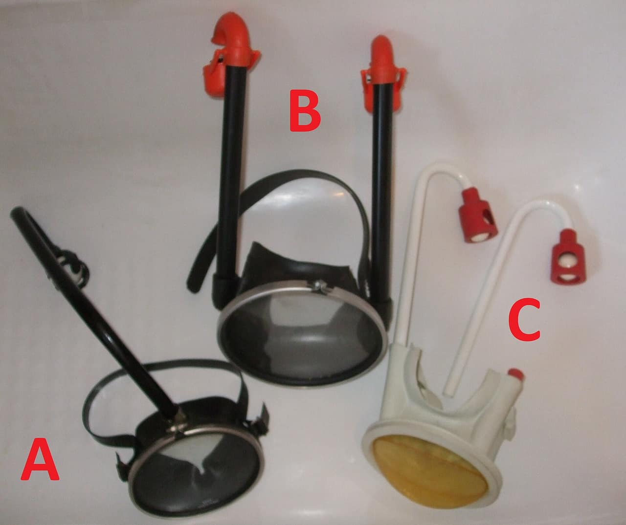 Three snorkel mask designs shown side by side, enclosing different amounts of the face